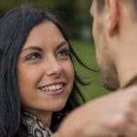 Eine Frau mittleren Altes umarmt ihren Freund und lächelt ihm in die Augen. Ihre Mimik strahlt ein gutes Selbstbewusstsein aus. Sie hat Schulterlange schwarze Haare und grüne Augen. Sie ist bekleidet mit einer braunen Jacke und einen schwarz/braunen Schaal. Im Hintergrund ist eine grüne Wiese zu sehen. Eine Frau mittleren Altes umarmt ihren Freund und lächelt ihm in die Augen. Ihre Mimik strahlt ein gutes Selbstbewusstsein aus. Sie hat Schulterlange schwarze Haare und grüne Augen. Sie ist bekleidet mit einer braunen Jacke und einen schwarz/braunen Schaal. Im Hintergrund ist eine grüne Wiese zu sehen.