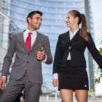 Ein Mann und eine Frau laufen eine Treppe hinunter und unterhalten sich dabei. Beide sind Arbeitskollegen und strahlen ein sehr starkes selbstbewusstsein aus. Er ist bekleidet mit einem hellgrauen Anzug, weisses Hemd und roter Kravatte und die Frau trägt eine schwarze Jacketjacke mit einem passend kurzen schwarzen Rock in Kniehöhe. Im Hintergrund ist ein Hochhaus mit einer Glasfassade zu sehen. Ein Mann und eine Frau laufen eine Treppe hinunter und unterhalten sich dabei. Beide sind Arbeitskollegen und strahlen ein sehr starkes selbstbewusstsein aus. Er ist bekleidet mit einem hellgrauen Anzug, weisses Hemd und roter Kravatte und die Frau trägt eine schwarze Jacketjacke mit einem passend kurzen schwarzen Rock in Kniehöhe. Im Hintergrund ist ein Hochhaus mit einer Glasfassade zu sehen.