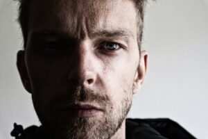 Hypnose bei Depression – 250 Fragen & Antworten | FAQ 2 Ein Mann blickt niedergeschlagen nach unten – visuelle Darstellung der emotionalen Belastung durch Depression, passend zu unserem umfassenden FAQ zur Hypnose-Therapie.
